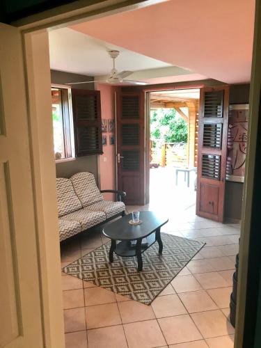 a living room with a table and a couch at Banan Woz in Bouillante