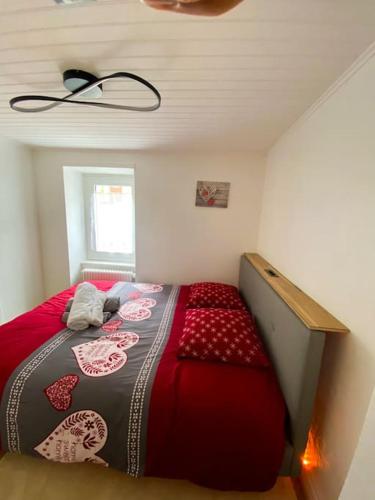 a small bedroom with a bed with a red blanket at Appartement typique avec Carnotzet in Crans-Montana