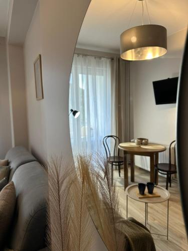 a living room with a couch and a table at APARTAMENTY LAVENDERIA z widokiem na Górę Parkową, blisko centrum in Kudowa-Zdrój
