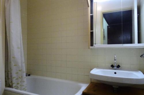 une salle de bain avec un lavabo, une baignoire et un miroir dans l'établissement Résidence Le Rochefort - Appartement 2 pièces 4 personnes à Bourg Saint Maurice proche du centre, de la piscine et de la zone de loisirs MAE-3084, à Bourg-Saint-Maurice