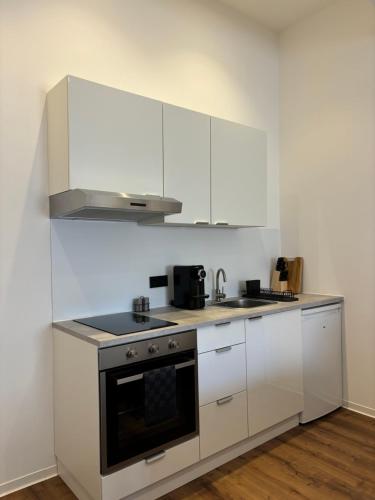 a kitchen with white cabinets and a stove top oven at Luxus Apartment mit Whirlpool in Kiel in Kiel