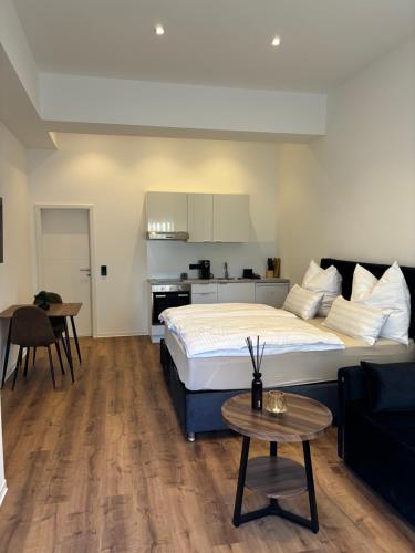 a bedroom with a large bed and a kitchen at Luxus Apartment mit Whirlpool in Kiel in Kiel