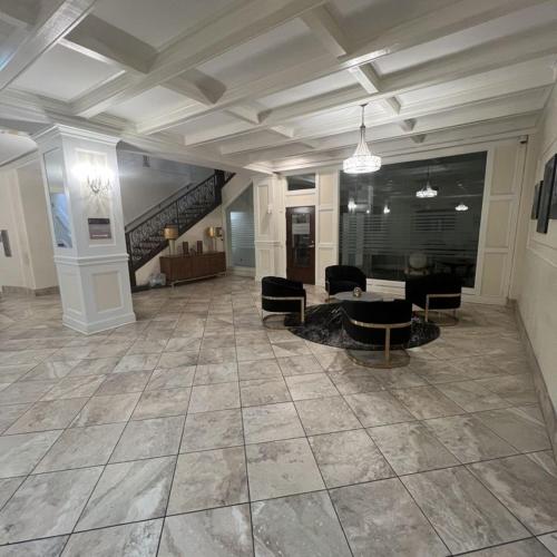 a large room with a lobby with chairs and a staircase at East 225 I Modern Studio In Downtown Rochester in Rochester