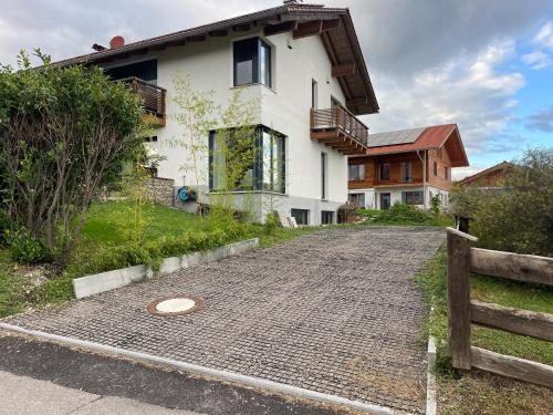 a house with a brick road in front of it at 80qm Appartement, 3 Schlaf-Zimmer, integrierter Küche und Bad, 2min von A8, Garten mit Sitzgruppe, ruhig und modern in Irschenberg