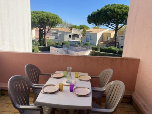 une table et des chaises assises sur un balcon dans l'établissement T2 avec piscine proche plage, au Cap d'Agde