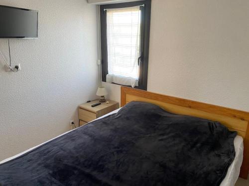 une chambre avec un grand lit et une fenêtre dans l'établissement T2 avec piscine proche plage, au Cap d'Agde