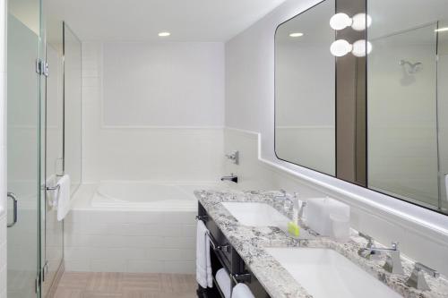 a bathroom with a sink and a tub and a mirror at Le Meridien Washington, DC, The Madison in Washington