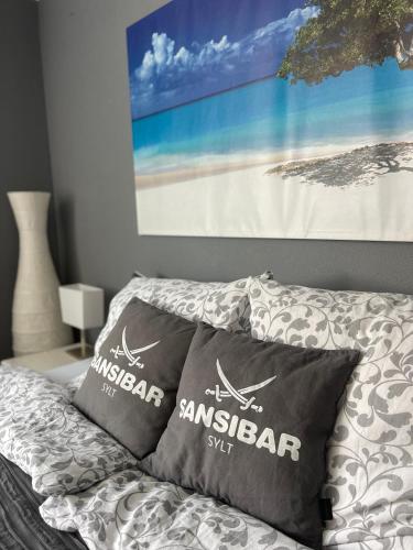a bedroom with two pillows on a bed with a painting at 80qm Appartement, 3 Schlaf-Zimmer, integrierter Küche und Bad, 2min von A8, Garten mit Sitzgruppe, ruhig und modern in Irschenberg
