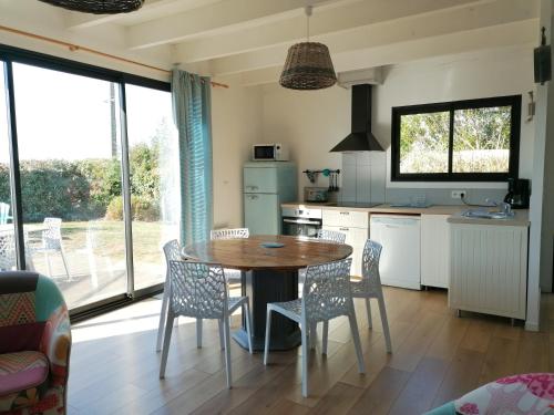 eine Küche mit Tisch und Stühlen in einem Zimmer in der Unterkunft Maison à 100 m de la plage, port et commerces à pieds -Les gîtes de Rhuys in Sarzeau