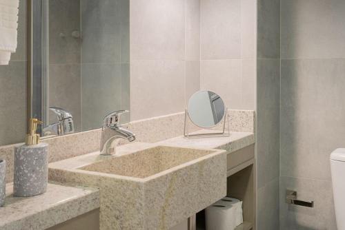 Un baño con dos lavabos y un espejo. en Lucas by Yoo por LikeHome, en Auxiliadora