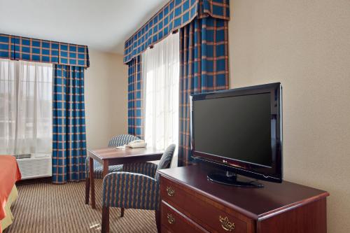 a hotel room with a flat screen tv on a dresser at Holiday Inn Express & Suites Jackson by IHG in Jackson