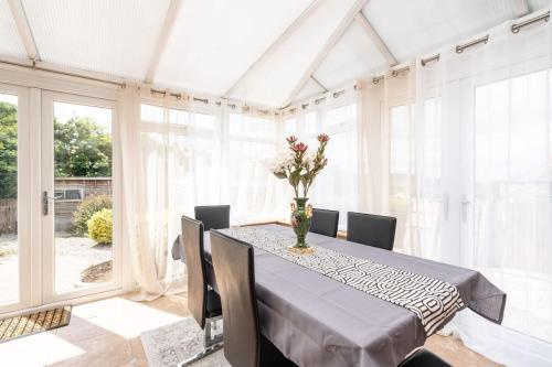 a dining room with a table with a vase of flowers on it at The Grove in Lawley Bank