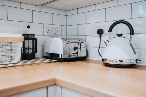 a kitchen counter with a toaster and a tea kettle at The Grove in Lawley Bank