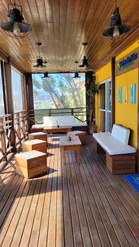 a room with benches and tables on a wooden deck at Apart Hotel Beira do Mar in Florianópolis