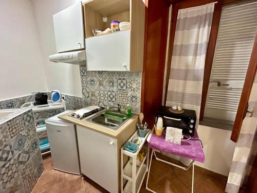 een kleine keuken met een spoelbak en een fornuis bij MAISON PALU' in Napels