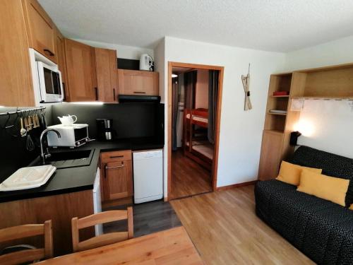 une cuisine et un salon avec un canapé dans une pièce dans l'établissement Résidence Le Chanteloup - Joli studio sur les pistes ! MAE-9284, à Aime La Plagne