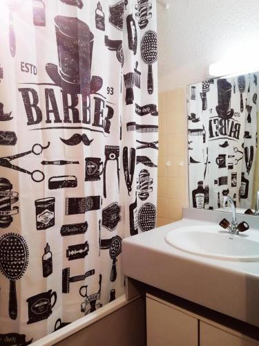 La salle de bains est pourvue d'un lavabo et d'un rideau de douche avec des outils. dans l'établissement Résidence Le Chanteloup - Joli studio sur les pistes ! MAE-9284, à Aime La Plagne