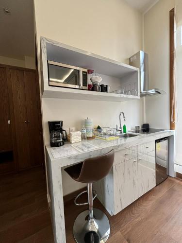 a kitchen with a counter with a sink and a microwave at Casa Herrmann Suites in Mexico City