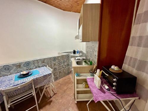 een kleine keuken met een tafel en een magnetron bij MAISON PALU' in Napels