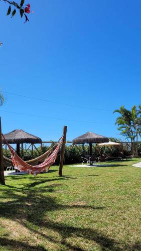 a hammock in a park with umbrellas at Apart Hotel Beira do Mar in Florianópolis