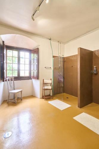 a large room with a shower and a chair at CASA RURAL PALACIO CONDE DE ALDANA con piscina entre encinares y dehesas in Terradillos
