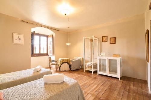 a hotel room with two beds and a mirror at CASA RURAL PALACIO CONDE DE ALDANA con piscina entre encinares y dehesas in Terradillos
