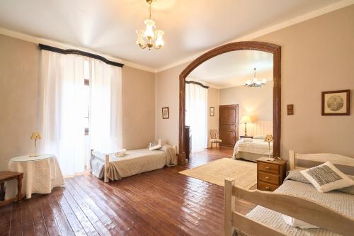 a bedroom with two beds and a large mirror at CASA RURAL PALACIO CONDE DE ALDANA con piscina entre encinares y dehesas in Terradillos