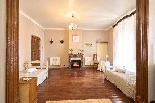 a living room with two beds and a fireplace at CASA RURAL PALACIO CONDE DE ALDANA con piscina entre encinares y dehesas in Terradillos