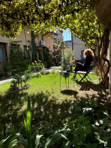 a woman sitting in a chair under a tree at Studio Rezistenta in Făgăraş