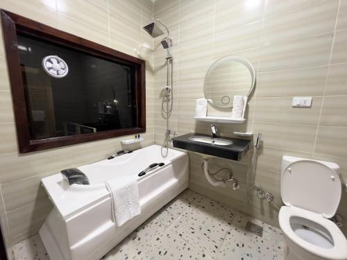 a bathroom with a tub and a sink and a toilet at Cheristo pyramids view inn in Cairo