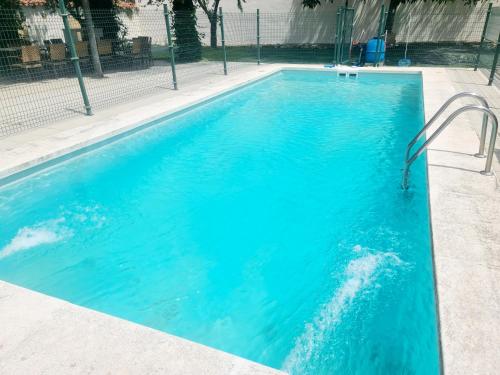 a swimming pool with blue water in a building at CASA RURAL PALACIO CONDE DE ALDANA con piscina entre encinares y dehesas in Terradillos