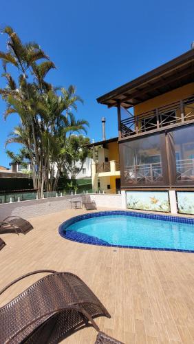 a swimming pool in front of a house at Apart Hotel Beira do Mar in Florianópolis