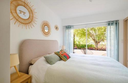 une chambre avec un lit et une grande fenêtre dans l'établissement Le Soleil d’or, à Théoule-sur-Mer