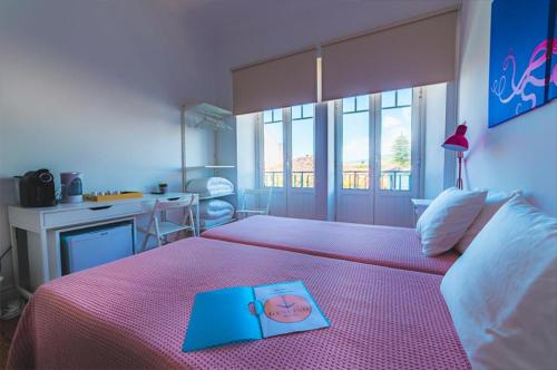 a bedroom with a bed with a book on it at Guest House Genuíno in Horta