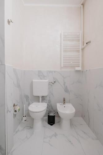 a white bathroom with a toilet and a sink at Alatea Porta Nuova 20 in Verona