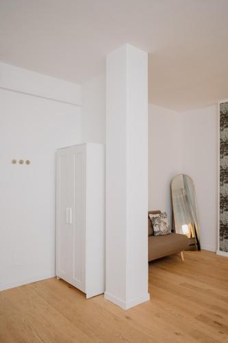 a white room with a door and a couch at Alatea Porta Nuova 20 in Verona