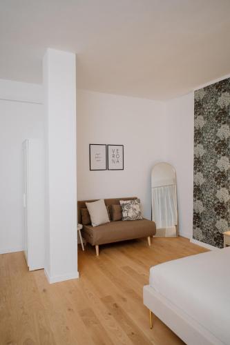 a white room with a bed and a couch at Alatea Porta Nuova 20 in Verona