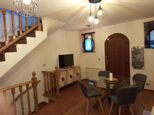 a living room with a dining room table and a staircase at Martínez Suite Burgos in Burgos