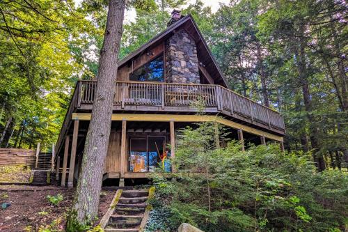 a cabin in the woods with a wrap around deck at Parker Pond's Perch in Poland Spring