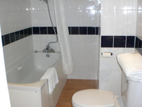 a bathroom with a tub and a toilet and a sink at Heathlands Hotel in Bournemouth