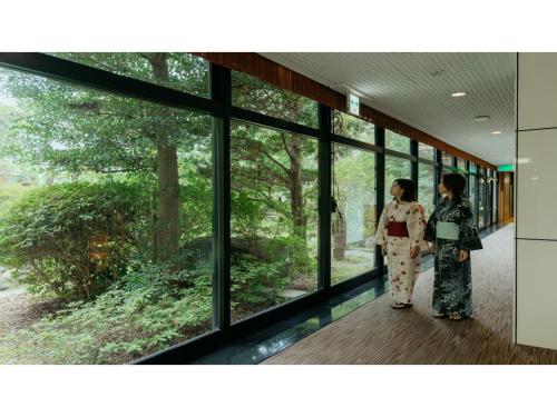 two women in kimonos standing in a building with windows at Tokigasane - Vacation STAY 15860v in Kaga