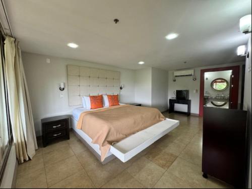 a bedroom with a large bed with orange pillows at Rancho Humo Estancia in Puerto Humo