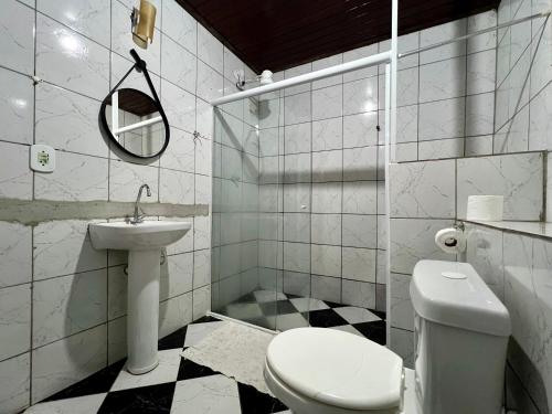 a white bathroom with a toilet and a sink at Espaço Verano - Suítes in Niterói