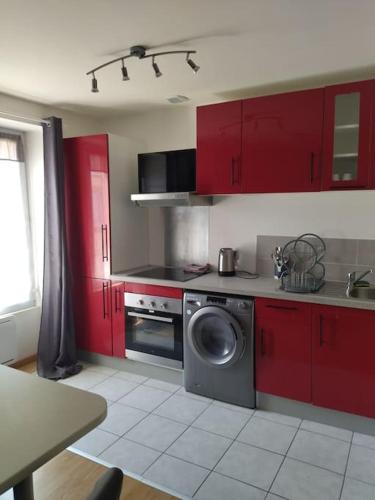 - une cuisine avec des placards rouges et un lave-linge dans l'établissement Appartement Brest Saint Martin avec belles prestations, à Brest