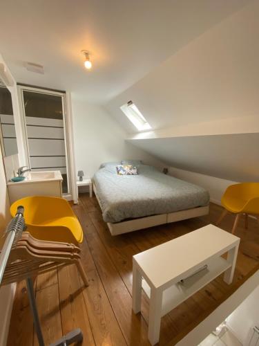 une chambre avec un lit, une table et des chaises dans l'établissement La petite amiénoise au calme, stationnement gratuit, à Amiens