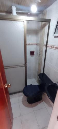 a bathroom with a blue toilet and a shower at apartamento Emanuel in Duitama