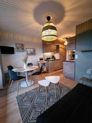 un salon avec une table et des chaises et une cuisine dans l'établissement Appartement bord de mer, à Dinard