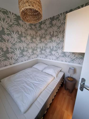 un lit dans une chambre avec un mur dans l'établissement Appartement bord de mer, à Dinard