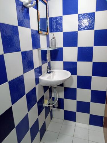 a bathroom with a sink and blue and white tiles at Hostal CasAlé Usaquén in Bogotá