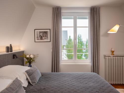 a bedroom with a bed and a window at Villa Berry Centre Deauville - Chic & Stylée - Magnifique Jardin in Deauville